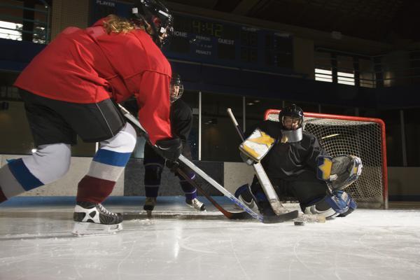 Hockey player skating in front of opposing goalie